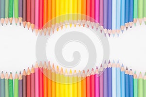 Colored pencils in rainbow order on white background.