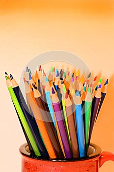 Colored pencils in red mug