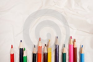 Colored Pencils for School on Crumpled white paper background