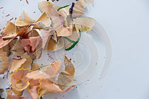 Colored pencils shavings on a white background