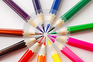 Colored pencils slates arranged in circle on white background, close-up selective focus