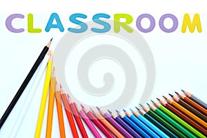 Colored pencils wave with alphabet sponge rubber of text `CLASSROOM ` over white background