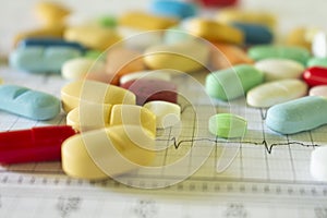 Colored pills on an electrocardiogram paper. Medications for cardiac patients