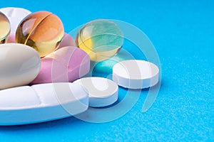 colored pills and multivitamins on a blue background. omega3