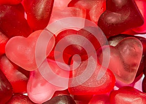 Colored (pink, red and orange), transparent heart shape jellies, colored degradee background