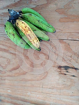 Colored plantain on a wooden background. PlÃ¡tanos de colores en un fondo de madera