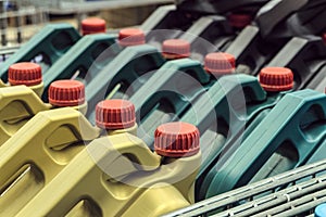 Colored plastic cans with engine oil. Rows of canisters placed on a pallet.