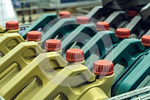 Colored plastic cans with engine oil. Rows of canisters placed on a pallet.