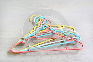 Colored plastic Clothes Hangers on wooden background