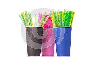 Colored plastic drinking straws in disposable cups isolated on white background