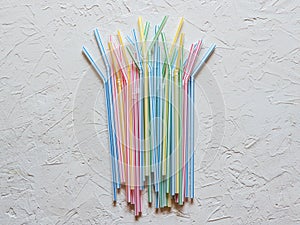 Colored plastic drinking straws on a white table.
