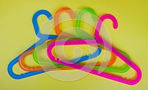 Colored plastic hangers on yellow background. Storage and sales concept