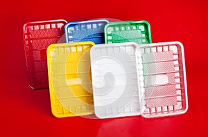 Colored plastic plates on red background