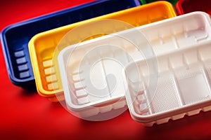 Colored plastic plates on red background