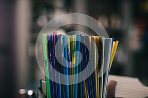 colored plastic straws for drinking on blurred background