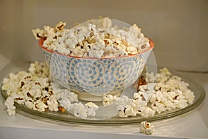 Colored plate with popcorn in the microwave, cook with microwaves. popcorn spilled from the plate. exploding corn kernels