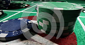 Colored poker chips with numbers on casino green betting table