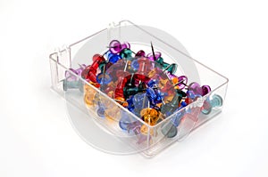 Colored push pins in a plastic box