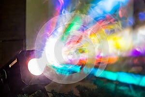 The colored rays of light from the searchlight through smoke. A theatrical performance, concert or disco. Lighting equipment