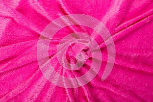 Colored rose textile satin fabric folded in folds and waves with highlights and texture