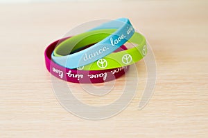 Colored rubber bracelets with inscriptions on beige background photo