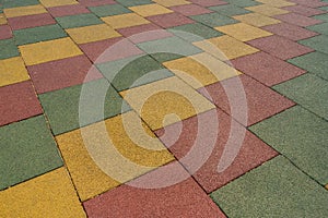 Colored rubber square paving slab for playgrounds close-up.