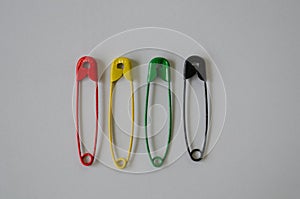 Colored safety pins on white background.