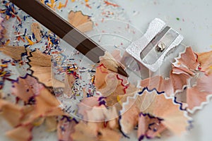 Colored shavings with brown color pencil and sharpener in saucer