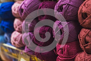 Colored skeins of wool on a store shelf. Woolen skeins for knitting all the colors of the rainbow, blue, brown, red and purple