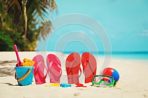 Colored slippers, toys and diving mask at beach
