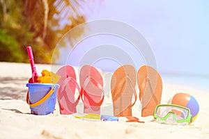 Colored slippers, toys and diving mask at beach