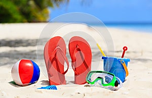 Colored slippers, toys and diving mask at beach