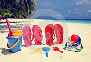 Colored slippers, toys and diving mask at beach