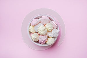 Colored small meringues on a pink background. Flat lay concept. Copy space