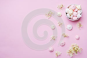 Colored small meringues on a pink background. Flat lay concept. Copy space