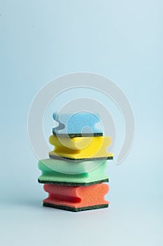 Colored sponges for washing dishes on a blue background. Minimal concept