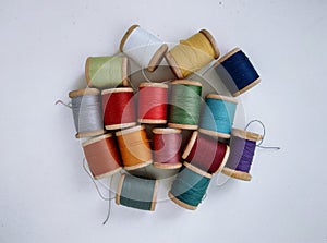 Colored spools of sewing thread on a white background top view.Sewing masks,clothes,multi-colored rainbow-colored threads.Small