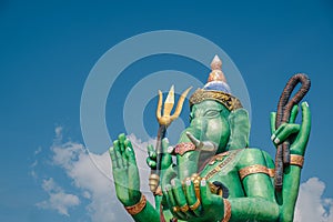 Colored statue of Hindu god called Ganesha on blue sky background