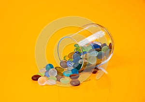 colored stones in glass in jar in bucket on orange background