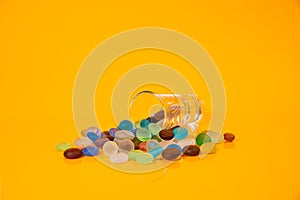 colored stones in glass in jar in bucket on orange background