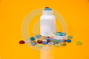 colored stones in glass in jar in bucket on orange background