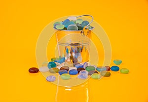 colored stones in glass in jar in bucket on orange background