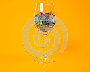 colored stones in glass in jar in bucket on orange background