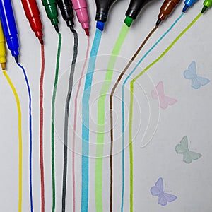 Colored stripes and colorful butterflies made by felt-tip pens and highlighters whose tip can be seen