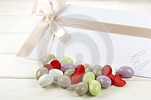 Colored sugared almonds and wedding paper