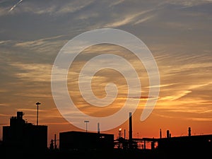 Colored sunset sky above dark industrial silhouettes