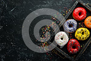 Colored sweet donuts in a wooden box.