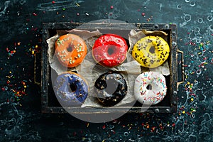 Colored sweet donuts in a wooden box.