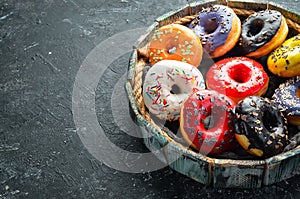 Colored sweet donuts in a wooden box.