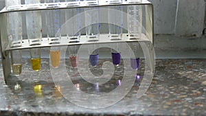 Colored test tubes in laboratory on an old window with marble window sill.